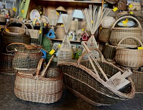 Verschiedene Transportkörbe für Holz, Picknick und modisches Accessoire sind hier zu sehen. Sie haben alle einen Tragegriff und sind in unterschiedlichen Farben und Formen gestaltet.