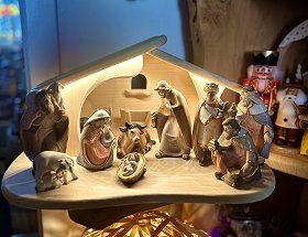 Die Geburt des Christkindes wird in dieser geschnitzten Krippe gezeigt. In einem hell erleuchteten, naturbelassenen Stall sind neben der Geburtsszene auch die heiligen drei Könige zu sehen.