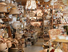 Blick in das Innere unseres Geschäftes, wo verschiedene geflochtene Korbwaren zu sehen sind. Sie sind mit warmen gelblichem Licht ausgeleuchtet.